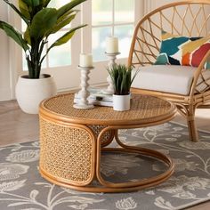 a wicker coffee table sitting on top of a rug next to a chair and potted plant