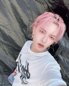 a young man with pink hair wearing a white shirt