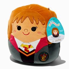 a harry potter plush toy with a tag on it's back and the hogwarts badge