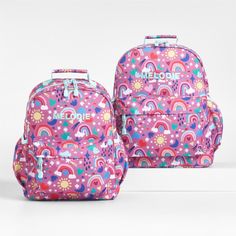 A backpack that's extra comfy and ready to handle daily adventures. A whimsical mix of raindrops, rainbows, stars and more shower the magenta exterior of our kids' large knapsack, and light aqua trim adds an extra burst of color. It's constructed of supremely durable polyester made from recycled water bottles and has a roomy interior to hold everything your kid needs—books, school supplies, extra layers. There's even a padded pocket to keep their tablet protected. Outside pockets hold snacks, wa Playful Rainbow School Bag, Rainbow-colored Standard Backpack For School, Rainbow Standard Backpack For Back To School, Rainbow School Backpack, Rainbow Colored School Backpack, Rainbow Standard School Backpack, Playful Pink Backpack For Outdoor Activities, Playful Purple Backpack, Books School