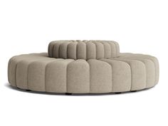 the circular couch is made out of fabric and has four legs, one foot on top of