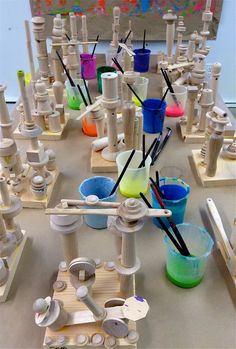 a table topped with lots of different types of paint and plastic cups on top of it