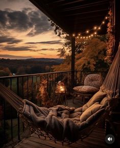 a hammock hanging from the side of a wooden deck with lights on it