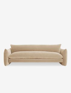 a beige couch sitting on top of a white wall