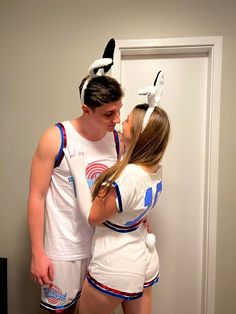 a man and woman in bunny ears kissing each other while standing next to a door