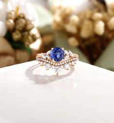 a tan and white ring with a blue stone surrounded by small diamonds on top of a table