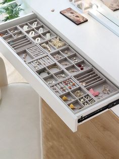 a white desk with drawers filled with jewelry