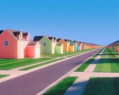 a row of colorful houses sitting on the side of a road next to a lush green field