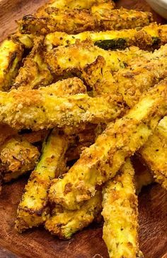 fried zucchini fries on a cutting board with text overlay that reads easy recipe artisan zucchini fries