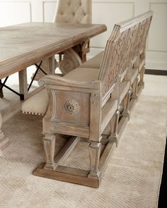 a dining room table with two chairs and a bench in the middle on carpeted floor