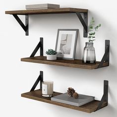 two wooden shelves with pictures, candles and other items on them