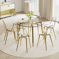 a round glass table with four chairs and a vase on it in front of a window