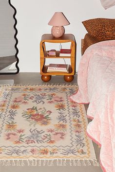 a bed room with a neatly made bed and a rug