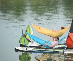 two people are sitting on small boats in the water with hammocks attached to them