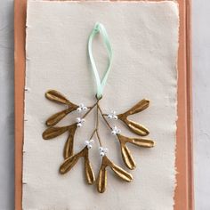 an ornament made out of gold leaf and white flowers on a piece of paper