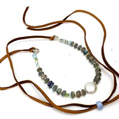 One of a kind handmade necklace with a mix of gemstone and metal beads including Labradorite, Freshwater Pearl, Aquamarine, Peridot, Iolite, and Thai Silver strung on softflex wire, and attached by Sterling Silver rings to a brown deerskin leather cord, with a vintage glass bead slider to adjust the length. Pull over the head and adjust the length to your liking by moving the glass bead. Beaded portion 9”, with 19.25” leather on each side Adjustable Labradorite Gemstone Beaded Necklaces, Labradorite Beaded Round Necklaces, Adjustable Labradorite Necklaces With Round Beads, Bohemian Adjustable Rondelle Beaded Necklaces, Adjustable Labradorite Gemstone Bead Necklace, Adjustable Round Labradorite Necklaces, Adjustable Round Labradorite Necklace, Adjustable Labradorite Necklace, Adjustable Beaded Labradorite Necklaces