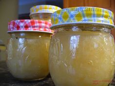 three jars filled with honey sitting on top of a counter