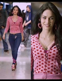 a woman in pink shirt and jeans walking down the runway