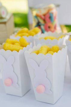 small white boxes with yellow and pink candies in the shape of bunny's ears