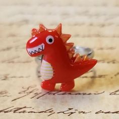 a red dragon ring sitting on top of a piece of paper