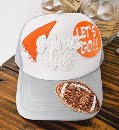 This listing is for a lightweight mesh trucker hat.  Gameday hat in Orange and White to support your favorite sports team-Longhorns.  This has the option of having the Glitter football on the brim or not!   Cap brand will vary. PERSONALIZATION: The look will vary based on available patches. But the product you receive will be similar to the pic. For the patches: (they may be chenille, embroidery, glitter, bling, or an appliqué) Please message me with any questions, I try to respond as quickly as Cheap Snapback Hats For Game Day, Football Trucker Hat With Patches, White Mesh Baseball Hats For Baseball Season, White Mesh Hat For Baseball Season, White Mesh Snapback Hat For Baseball Season, White Mesh Snapback Hat For Baseball, Mesh Snapback Hat For Baseball Season Sports Events, Baseball Cap For Tailgating During Baseball Season, Baseball Mom Trucker Hat