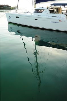 a white boat floating on top of a body of water