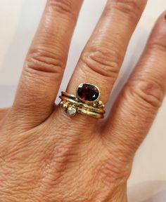 14Kt yellow solid gold asymmetric wrap around statement ring bezel set with a faceted 8x6mm oval garnet and a 2mm diamond accent.  Size 7 1/2. Designed and handcrafted by Richelle Leigh using the lost wax casting process. Free shipping US. https://www.etsy.com/shop/RichelleJewelry Oval Stackable Ruby Ring In Yellow Gold, Yellow Gold Garnet Rings With Gemstone Accents, Gold Rings With Rose Cut Diamonds And Garnet, Gold Garnet Ring With Rose Cut Diamonds, Large Garnet Ring, Garnet Ring Silver, Three Necklaces, Statement Rings Diamond, Ring Bezel