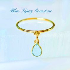 This Blue Topaz Engagement Ring features a teardrop gemstone, handcrafted in 14k gold-filled and perfect as a December birthstone for jewelry lovers. Available in sizes 4-8, this unique handmade dangling charm ring is an elegant gift for her. 💍  ✦100% handcrafted ✦ High quality 14k yellow gold-filled and light blue topaz gemstone ✦ Ring arrives in either a pink microfiber suede envelope/pouch or a blue/green drawer cardboard box as seen in the last image of this listing. ✦ Ready to ship in one business day ✦ Average shipping time (US/Canada/UK) three to five business days  ✦ Tracking available ✦Pear-shaped blue topaz gemstone bezel encased in a 14k gold frame Size--4mmx6mm Color-blue Shape--pear Material--14k yellow gold and blue topaz gemstone ✦Band Style--2mm textured, 2mm smooth or 1mm Fine Jewelry Yellow Gold Topaz Teardrop Ring, Fine Jewelry Yellow Gold Topaz Ring With Teardrop, Anniversary Yellow Gold Teardrop Topaz Ring, Teardrop Topaz Ring Gift, Teardrop Topaz Ring For Gift, Teardrop Topaz Ring For Anniversary, Gold Pear-shaped Topaz Ring Gift, Anniversary Teardrop Topaz Ring, Teardrop Blue Topaz Ring Gift