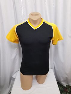 Vintage 1980's Bike Brand Black with Yellow Sleeves & Neckline Short Sleeve Poly Cotton Polo Top Shirt Pullover Streetwear T Shirt.  The material does have stretch.  Shirt is in Great vintage condition (some imperfections from wear) - See pics! Measurements: shoulder to shoulder 17 in, chest 36 in, sleeves shoulder to cuff 7, sleeves pit to cuff 5, back of neck to waist 26 inches. Vintage Black V-neck Top, Yellow Short Sleeve Grunge T-shirt, Vintage Yellow Short Sleeve T-shirt, Yellow Color Block Short Sleeve T-shirt, Yellow Short Sleeve Pop Culture T-shirt, Vintage Short Sleeve T-shirt For Motorcycling, Velo Vintage, Bike Brands, Streetwear Tshirt