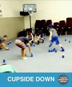 several people are playing with cups in an indoor gym