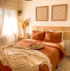 a bed with an orange comforter and pillows