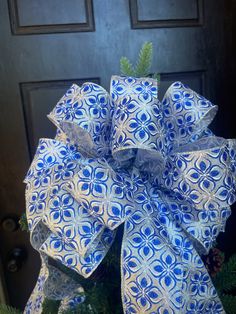 a blue and white bow on top of a christmas tree