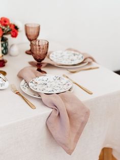 a white table topped with plates and glasses