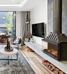 a living room filled with furniture and a flat screen tv mounted on a wall next to a fire place