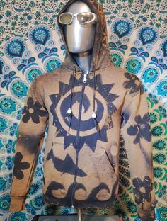 One of a kind, handcrafted bleach art hoodie, featuring a radiant sunburst design paired with daisy flowers and ocean waves. Each pattern is created by hand stenciling and bleaching the fabric. Original sweatshirt is black with bleached out / light brown design.  Care Instructions: Machine wash cold with like colors, inside out. Tumble dry low or hang to dry. T-shirt comes pre-washed and dried. Artistic Cotton Sweatshirt For Winter, Artistic Cotton Hoodie, Artistic Cotton Hooded Hoodie, Brown Cotton Hoodie For Spring, Fall Festival Casual Hoodie, Casual Fall Festival Hoodie, Tie Dye Graphic Print Hoodie, Hippie Hooded Hoodie For Festivals, Hippie Hooded Festival Hoodie