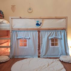 a bunk bed with curtains and pillows on top of it in a child's room