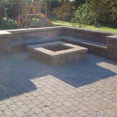 a brick patio with seating area and fire pit