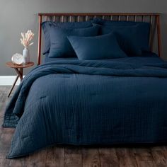 a bed with blue sheets and pillows in a room