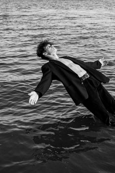 a man floating in the water wearing a suit