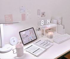 a desk with a computer, keyboard, mouse and alarm clock sitting on top of it