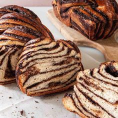 several loaves of bread sitting on top of a cutting board next to each other