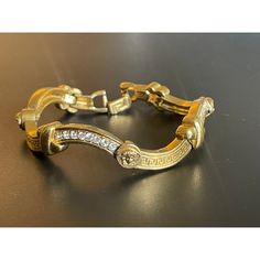 Rare Gianni Versace gold tone linked bracelet, embellished with glass crystals, Greek key design and Medusa motif.  Not adjustable -- best fits a small to medium wrist. Circa early 1990s. Luxury Metal Bracelets With Gold-tone Hardware, Adjustable Gold-tone Jewelry For Gifts, Designer Gold Bracelets For Formal Occasions, Designer Gold-tone Metal Jewelry, Elegant Metal Bracelets With Gold-tone Hardware, Elegant Adjustable Bracelet With Gold-tone Hardware, Elegant Adjustable Bracelets With Gold-tone Hardware, Designer Gold Metal Chain Bracelet, Designer Gold Bracelets With Gold-tone Hardware