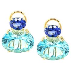 These impressive earrings feature a beautifully matched pair of Swiss blue topazes that have a combined weight of over 23 carats! The large sparkling ovals are set horizontally with gorgeous African tanzanites in an original color block design that is both contemporary and timeless. Handcrafted in 18k yellow gold by our Master Jewelers in Los Angeles, these bright pops of color will give a look of updated elegance to both casual and dressy attire! Perfect for both daytime and evening wear! Earrings measure 3/4" in length, 5/8" across Swiss blue topazes, 16 x 12mm, 23.66 carats total Tanzanites, 8 x 6mm, 2.68 carats total