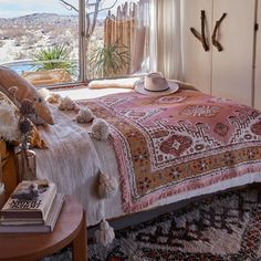 a bedroom with a large bed covered in blankets and tassels next to a window