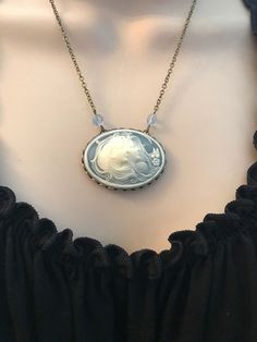 "Here is a vintage inspired blue cameo necklace featuring two lovely women with flowing hair on the front, the cameo ladies are bright white and are set against a beautiful sky blue background. This cameo is set in an oxidized brass setting and is suspended from two faceted blue glass beads and a nice quality brass chain. You may select your desired chain length from the drop down menu. This necklace is would make a lovely gift for sisters or lovers. Handcrafted in the USA. Shipped in a lovely g Handmade Victorian Jewelry With Oval Pendant, Victorian Handmade Oval Pendant Jewelry, Handmade Victorian Oval Pendant Jewelry, Victorian Cameo Round Pendant Jewelry, Cameo Round Pendant Necklace For Wedding, Victorian Blue Cameo Jewelry, Cameo Medallion For Jewelry Making, Brass Cameo Jewelry As A Gift, Brass Cameo Jewelry Gift