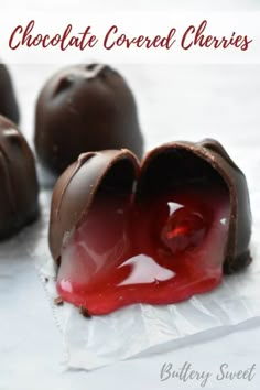 chocolate covered cherries with red liquid in the center and on top of white paper