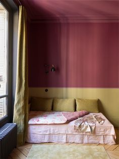 a bed sitting under a window next to a radiator