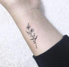 a small flower tattoo on the wrist