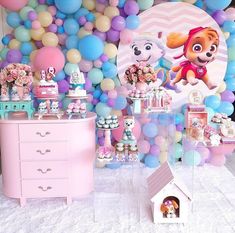 a room filled with lots of balloons and decorations on the wall next to a dresser