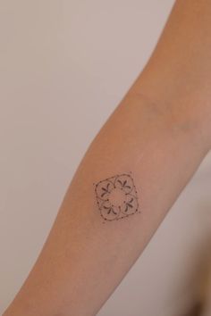 a person's arm with a small tattoo design on the left side of their arm